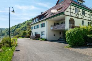a large white building with a red roof at Merk Ferienwohnungen Gbr in Bodman-Ludwigshafen