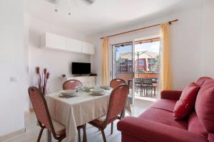 a living room with a table and a red couch at Little Dunes in Corralejo