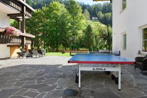 a ping pong table sitting on a patio with at Hotel Residence Olympia Sarntal in Sarntal