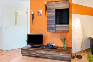 a television on a dresser in a room at Ferienwohnung Im Holzhaus in Donaueschingen