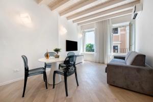 a living room with a table and a couch at Aa Imbarcadero apartments in Salò