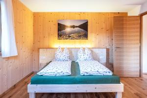 a bedroom with a bed in a wooden wall at Mittnackerhof Apartment Kamille in Sarntal