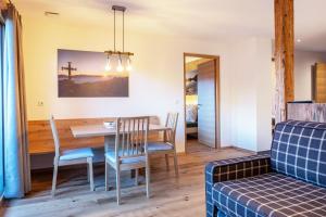 a dining room and living room with a table and chairs at Mittnackerhof Apartment Kamille in Sarntal