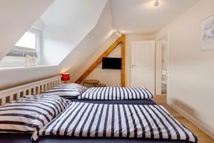 two beds with striped pillows in a room at Sabines Ferienwohnung in Glückstadt