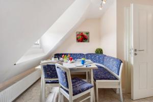 a dining room with blue chairs and a table at Sabines Ferienwohnung in Glückstadt
