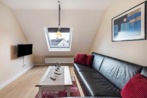 a living room with a leather couch and a coffee table at Sabines Ferienwohnung in Glückstadt