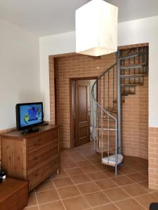 a living room with a staircase and a television at Casa Sagres in Vila do Bispo