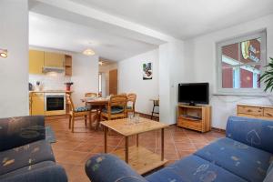 a living room with a blue couch and a table at Haus Seeadler Wohnung 13 in Koserow +28 photos