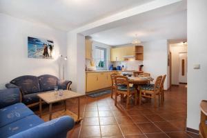 a kitchen and a living room with a table and chairs at Haus Seeadler Wohnung 13 in Koserow