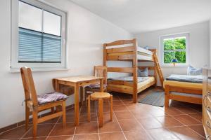 a bedroom with a bunk bed and a desk and chair at Haus Seeadler Wohnung 13 in Koserow
