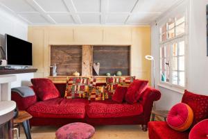 a living room with a red couch and red chairs at Schwarzwaldcasa in Todtmoos