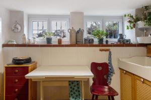 a kitchen with a table and a red chair at Schwarzwaldcasa in Todtmoos +33 photos