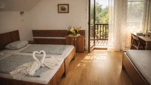 a bedroom with two beds and a desk and a balcony at Ekofarma Sádky in Uherské Hradiště