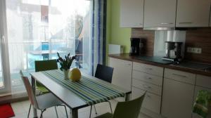 a kitchen with a table and chairs and a table and a window at Ferienwohnung Stella Fiante in Juliusruh