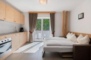 a hotel room with two beds and a kitchen at Hotel Residence Olympia Sarntal in Sarntal