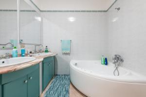 a white bathroom with a tub and a sink at Casa Vacanza Casi 1 in Villasimius