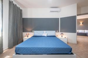 a bedroom with a blue bed with two night stands at Casa Vacanza Casi 1 in Villasimius