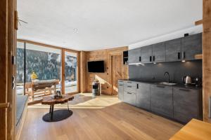 a kitchen with gray cabinets and a large window at Chalet-Suite Wasser in Selva dei Molini +34 photos