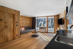 a kitchen with wooden walls and a living room at Chalet-Suite Wasser in Selva dei Molini