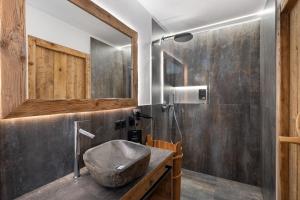 a bathroom with a stone sink and a shower at Chalet-Suite Wasser in Selva dei Molini
