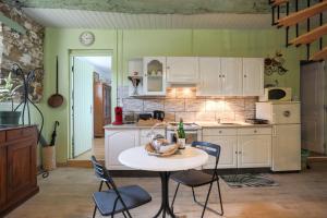 a kitchen with a table and chairs in a room at L'abreuvoir du Leffo in Allineuc