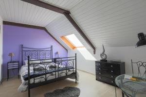 a bedroom with purple walls and a bed and a window at L'abreuvoir du Leffo in Allineuc