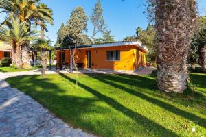 a yellow house with palm trees in front of it at Le dimore di Elia in Lecce
