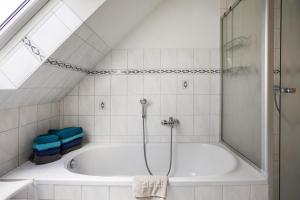 a bathroom with a bath tub with a shower at Ferienwohnung Nico in Langballig +23 photos