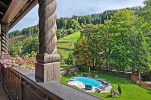 a balcony with a view of a yard with a pool at Hotel Residence Olympia Sarntal in Sarntal