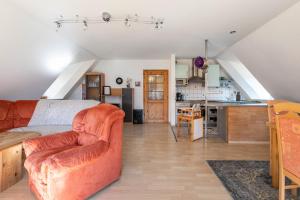 a living room with a couch and a kitchen at Hus Tingeltut Gerd Clausen in Pellworm