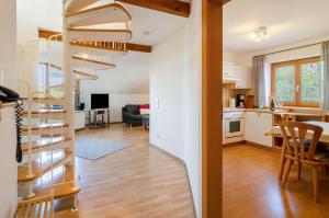 a kitchen and a living room with a spiral staircase at Ferienwohnung Keller in Hagnau