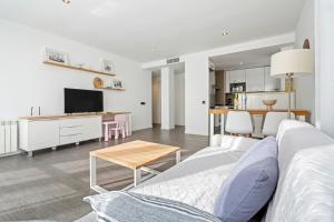 a living room with a couch and a table at Ap Calafell piscina, climatizado,pk in Calafell