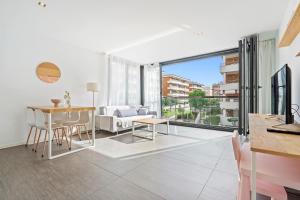 a kitchen and living room with a table and chairs at Ap Calafell piscina, climatizado,pk in Calafell
