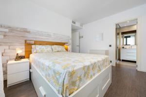 a bedroom with a large bed with a wooden headboard at Ap Calafell piscina, climatizado,pk in Calafell +11 photos