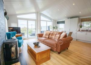 a living room with a couch and a fireplace at Drumcarrow Luxury Lodges in St. Andrews