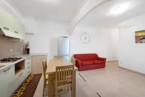 a kitchen with a table and a red couch at Il Porto in Celle Ligure