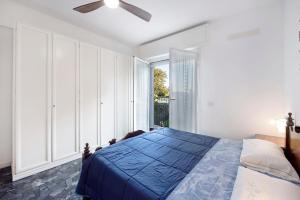 a bedroom with a blue bed and a window at Il Porto in Celle Ligure