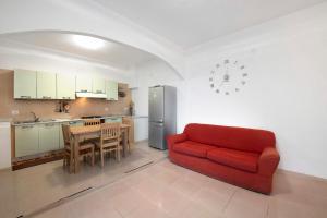 a living room with a red couch and a kitchen at Il Porto in Celle Ligure +13 photos