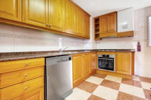 a kitchen with wooden cabinets and a dishwasher at La bodegueta in Orba +12 photos