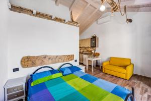 a bedroom with a bed and a yellow chair at Pelagos in Pompeiana +25 photos