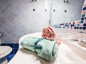 a bathroom with a toilet and towels on a sink at Mono Le Lecce 53 Iris in Capoliveri +22 photos