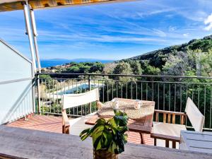 a patio with a table and chairs on a balcony at Mono Le Lecce 53 Iris in Capoliveri