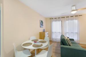 a living room with a table and a green couch at Apartamento Con Piscina Arinaga in Arinaga