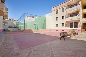 a bench in a courtyard in front of a building at Apartamento Con Piscina Arinaga in Arinaga