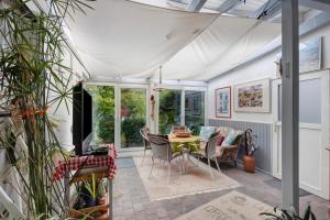a conservatory with a table and chairs in a room at Ferienhaus Marchlewski in Brunsbüttel