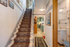 a staircase in a house with a woman standing next to it at Ferienhaus Marchlewski in Brunsbüttel +18 photos