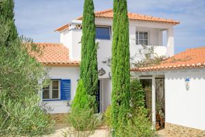 a white house with trees in front of it at Casa Alecrim - Selão da Eira in Pedreneiras