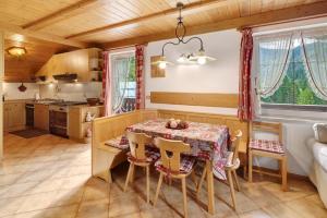 a kitchen and dining room with a table and chairs at Mansarda Maema in Moena