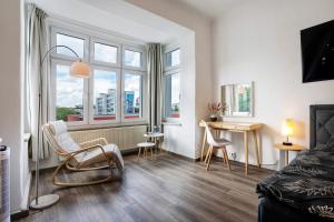 a living room with a bed and a desk and windows at Ferienwohnung Chemnitz City in Chemnitz