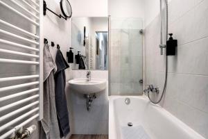 a white bathroom with a sink and a bath tub at Ferienwohnung Chemnitz City in Chemnitz +15 photos